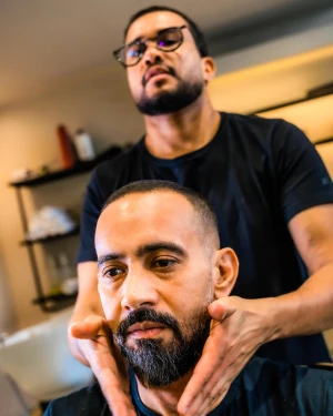 Barbeiro ajustando barba de cliente na The Barbers Aju, Aracaju