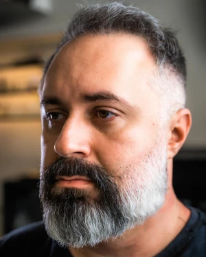 Corte masculino com degradê e barba grisalha na The Barbers Aju, Aracaju